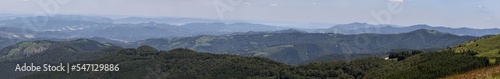 Maxi panoramic photo of the endless Balkans, overgrown with forests with valleys and meadows in a summer haze, Bulgaria