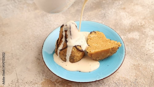 caramel soft cake sprinkled with milk sauce on a brown concrete background. Side view, close up.