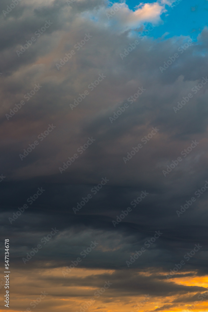 Dramatic clouds at sunrise or sunset. Cloudscape vertical photo