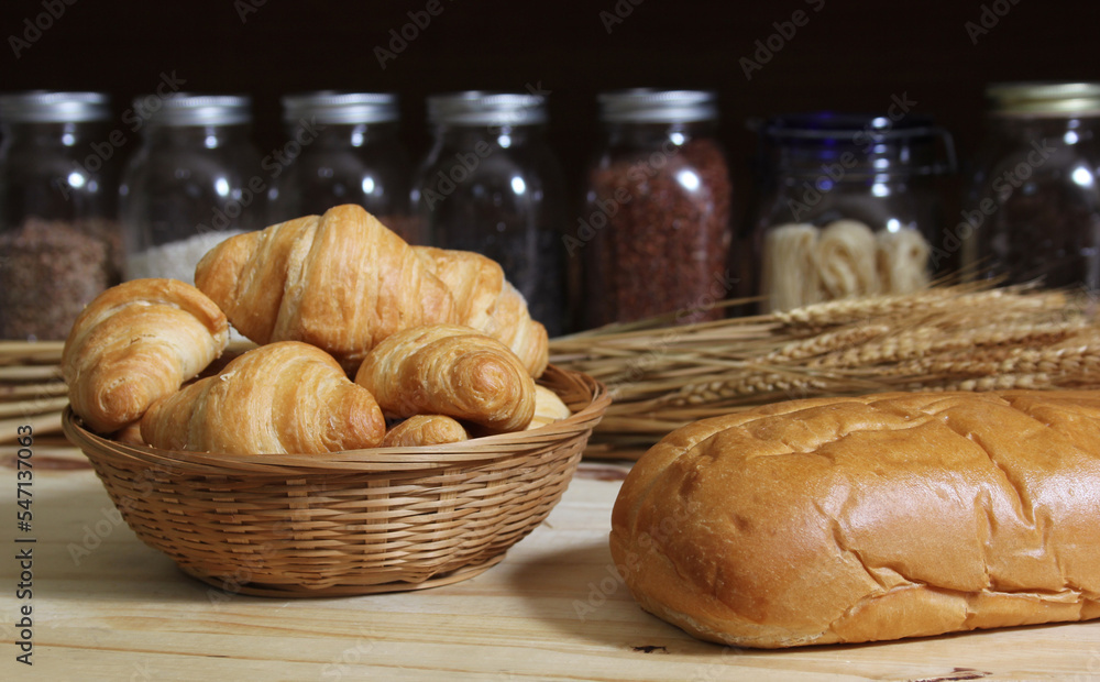 Fresh Baked Bread in Rustic Kitchen on Wooden Table With Jars of Dried Food in Background Shallow DOF