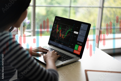 Young business woman using computer trading stock market exchange online. Trader analyzing data and investment concept.
