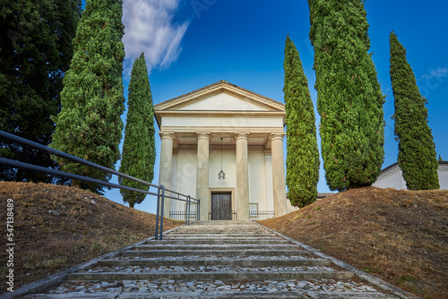 An einer Treppe, die zu einem Friedhof in Pieve di Soligo führt, steht eine Halle mit vier Säulen photo