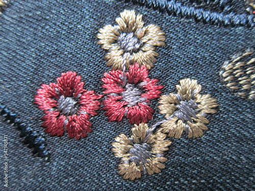 Embroidery on denim in the form of small flowers.