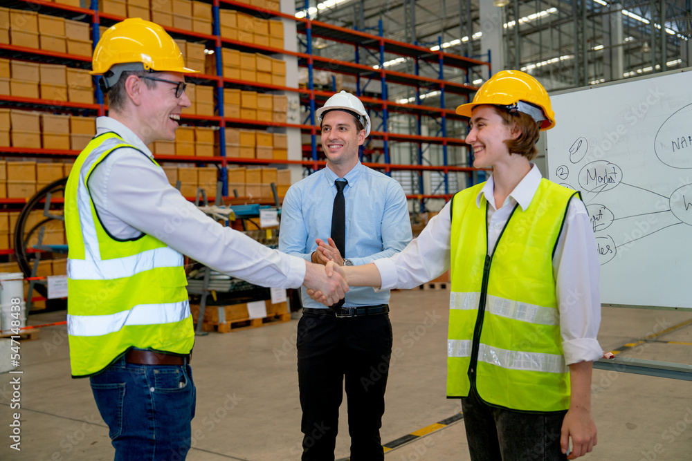 Professional manager clap hands for the team with warehouse worker man shake hands with co-worker woman and they smiling with happiness. Professional manager clap hands for the team with warehouse worker man shake hands with co-worker woman and they smiling with happiness.