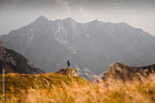 Schilderij op canvas A hiker is enjoying the view from a cliff in the Orobie Alps, Northern Italy