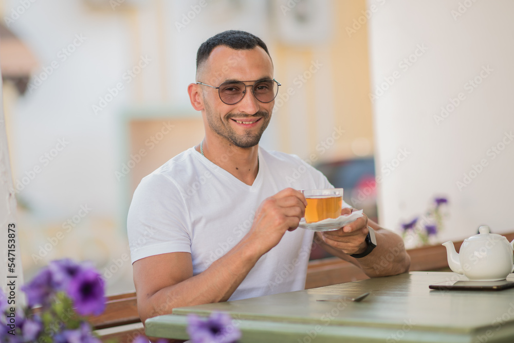 a cute man is drinking tea in a cafe on the street, a sexy guy is having breakfast in a cafe a cute man is drinking tea in a cafe on the street, a sexy guy is having breakfast in a cafe