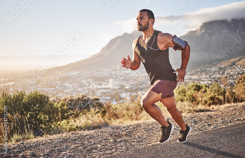 Фотография Fitness, sports and man running on mountain with city background doing marathon training