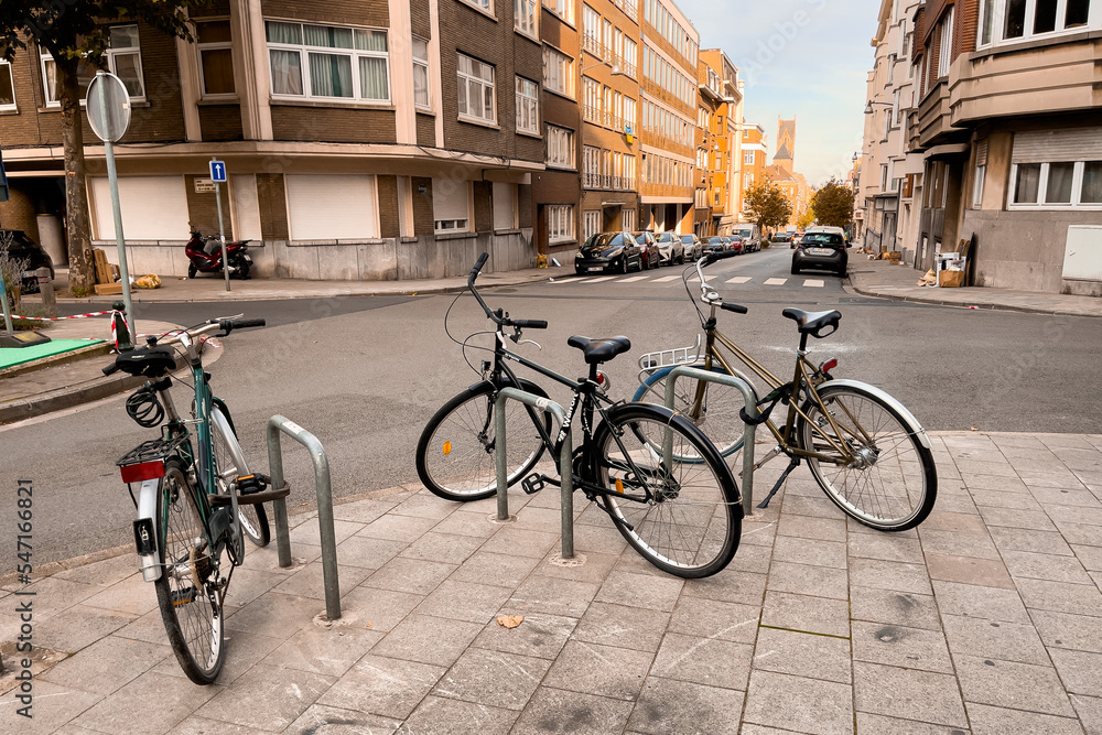 Three conventional bikes locked onto a bicycle rack in the street in Brussels