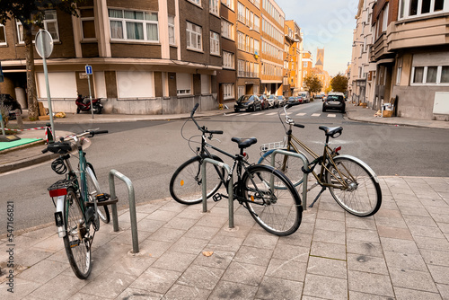 Three conventional bikes locked onto a bicycle rack in the street in Brussels © Mounir