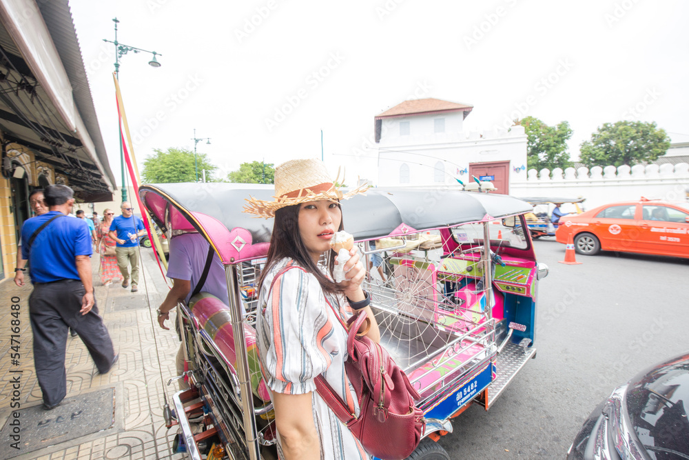 Asian traveller woman walking on street food eat ice cream sunny day