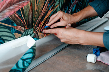 young man trims the edges of the wallpaper