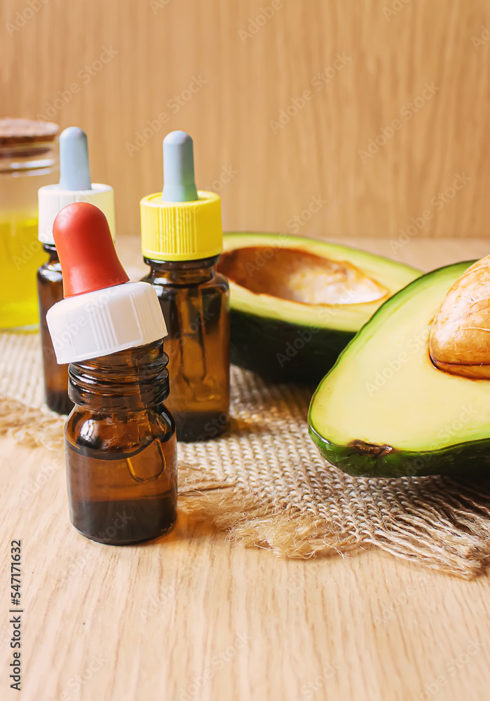 Avocado and avocado oil on wooden background. Selective focus. Avocado and avocado oil on wooden background. Selective focus.