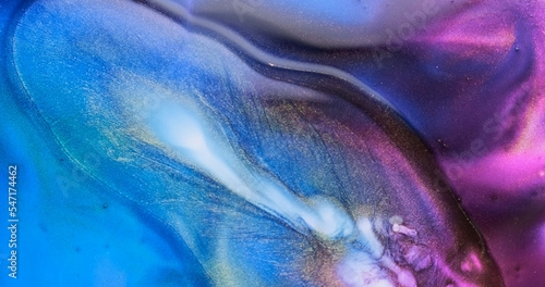 Blue purple liquid abstract background. Fluid art splash. Brilliant blue lilac paint spreads sparkling with glitter. Golden particles sparkle in colorful blue-purple watercolor backdrop