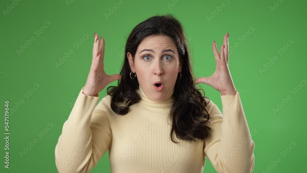 Pretty thinking young woman 20s, looks at camera gives mind blown gesture showing explosion of ideas posing on green screen background. Pretty thinking young woman 20s, looks at camera gives mind blown gesture showing explosion of ideas posing on green screen background.