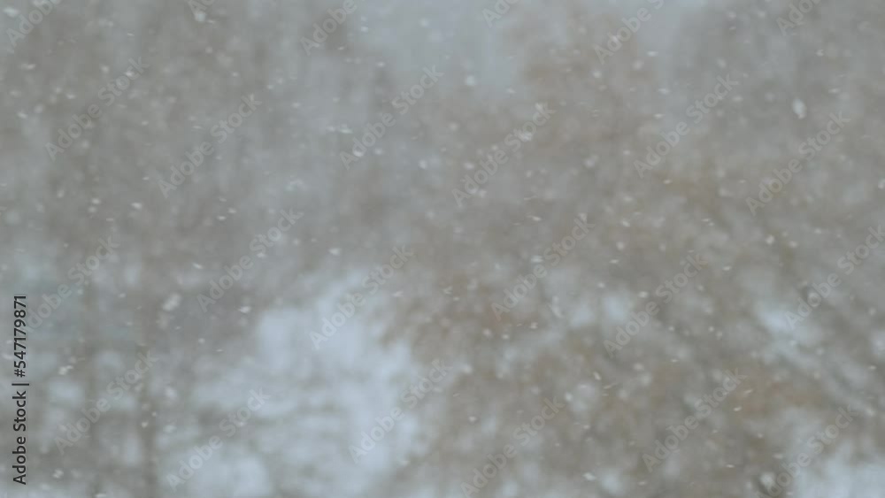 Falling snow, blurred winter background. Defocused snowflakes flying and spinning in the air. Blizzard outside the window. Falling snow, blurred winter background. Defocused snowflakes flying and spinning in the air. Blizzard outside the window.