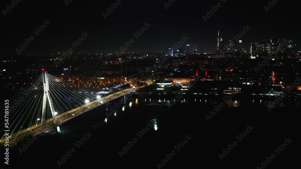 Scenic aerial view of night car traffic on illuminated suspension bridge with Warsaw in 4K urban cityscape, advanced innovation, financial technology Warsaw. Poland Scenic aerial view of night car traffic on illuminated suspension bridge with Warsaw in 4K urban cityscape, advanced innovation, financial technology Warsaw. Poland