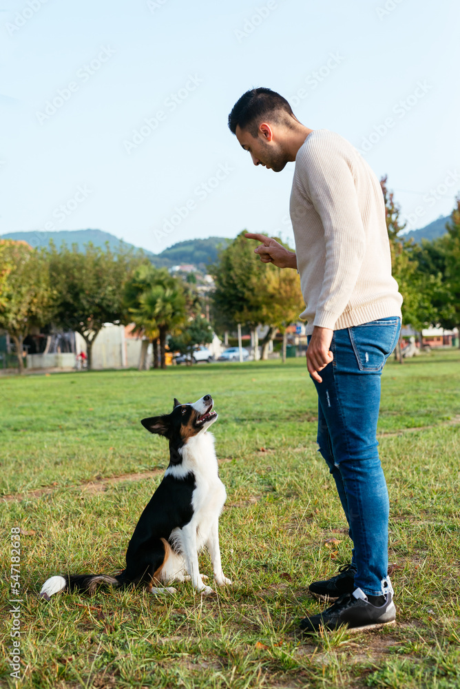 Young man playing with dog in park Young man playing with dog in park