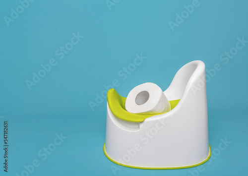 Toilet paper in a baby pot. Photographed against a blue background.