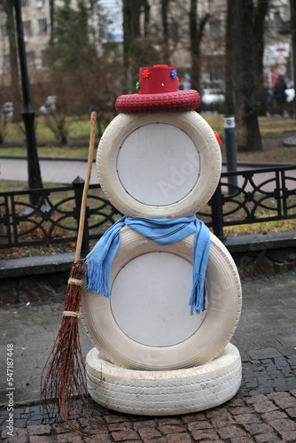 Snowman with a broom. New Year's installation from outworn car tires.
