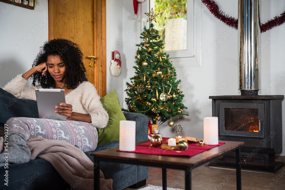 Black woman browsing tablet on couch Black woman browsing tablet on couch