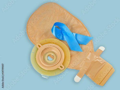 One colostomy bag and colostomy disc on blue background .Blue ribbon .Symbol of colon cancer photo
