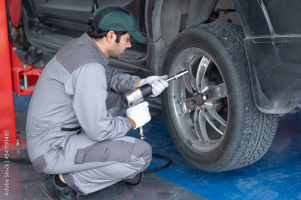 Professional mechanic providing car repair and maintenance service in auto garage. Car service business concept. Professional mechanic providing car repair and maintenance service in auto garage. Car service business concept.