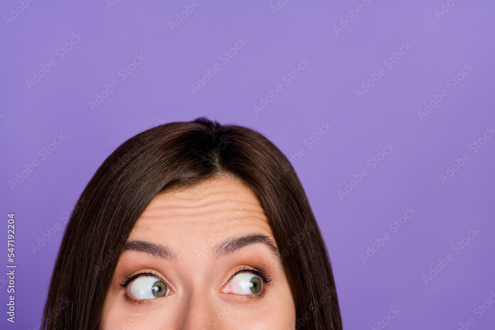 Close up cropped portrait of half face minded lady look interested empty space isolated on purple color background Close up cropped portrait of half face minded lady look interested empty space isolated on purple color background