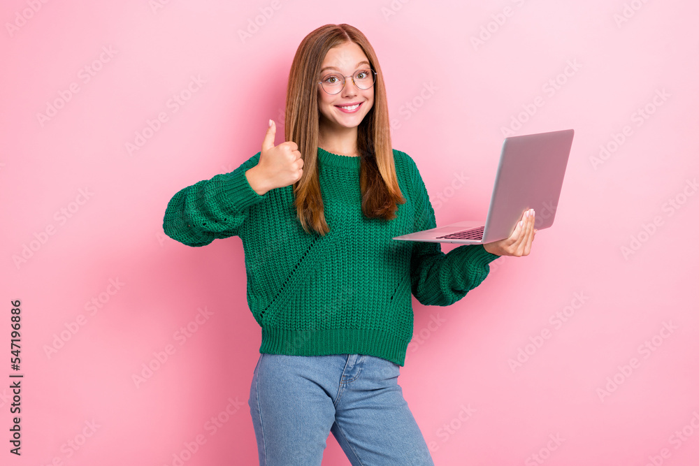 Photo of young gorgeous girlish woman wear green stylish knitted sweatshirt denim jeans showing thumb up like hold laptop isolated on pink color background Photo of young gorgeous girlish woman wear green stylish knitted sweatshirt denim jeans showing thumb up like hold laptop isolated on pink color background