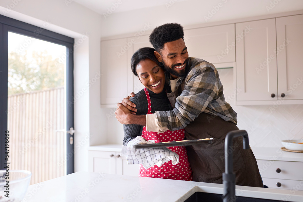 Couple At Home With Homemade Cookies On Tray Together In Kitchen Couple At Home With Homemade Cookies On Tray Together In Kitchen