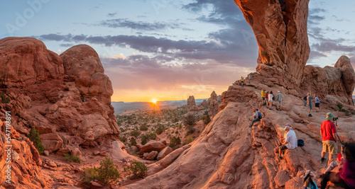 Leinwand Poster Crowds to watch the Sunrise at the North Window Arch at Arches National Park - W