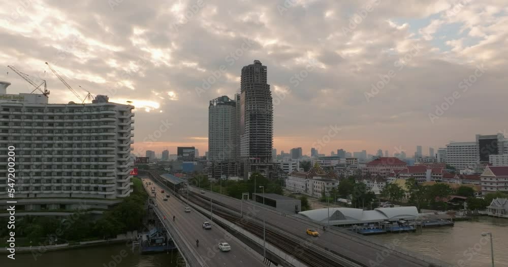 Aerial view of Taksin Bridge and Sathorn Road center of business with transportation over the Chao Phraya River at sunrise scene, Bangkok, Thailand. Aerial view of Taksin Bridge and Sathorn Road center of business with transportation over the Chao Phraya River at sunrise scene, Bangkok, Thailand.