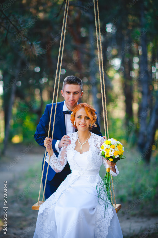 Young beautiful couple in a blue suit and white wedding dress with a bouquet Young beautiful couple in a blue suit and white wedding dress with a bouquet
