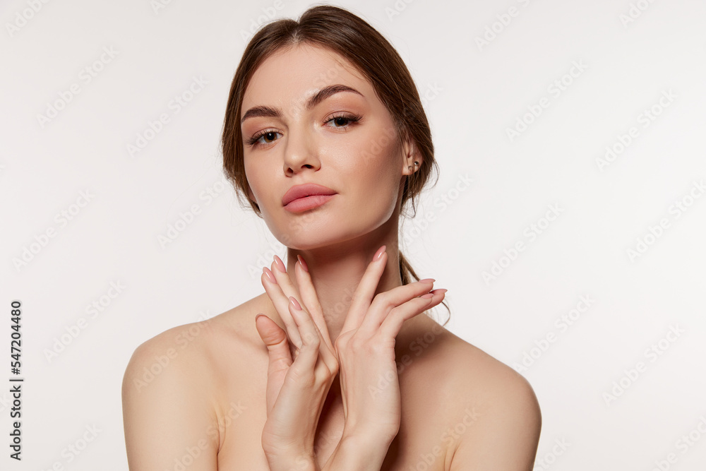 Portrait of young beautiful woman with perfect smooth skin isolated over white background. Facebuilding. Portrait of young beautiful woman with perfect smooth skin isolated over white background. Facebuilding.