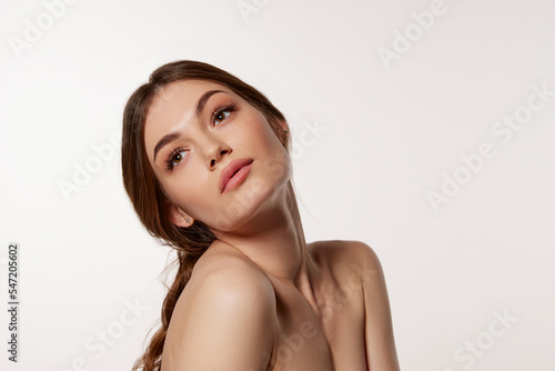 Portrait of young beautiful woman with perfect smooth skin isolated over white background. Tender female beauty