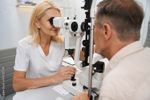 Ophthalmologist examining the eyeball of patient in cabinet