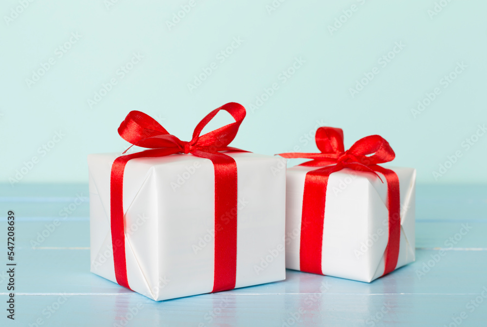 Obraz premium Gift boxes with red ribbon bow on color background