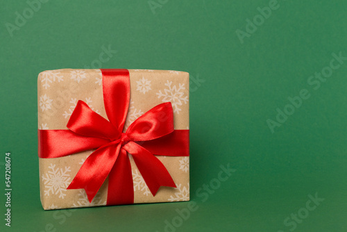Gift box with red ribbon bow on color background
