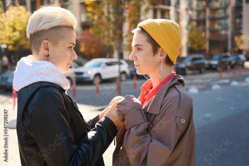 Women, lgbt couple, stand against the backdrop of autumn cityscape