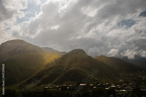 Stepancminda Gruzja widok latem w stronę góry Kazbek przy częściowym zachmurzeniu.