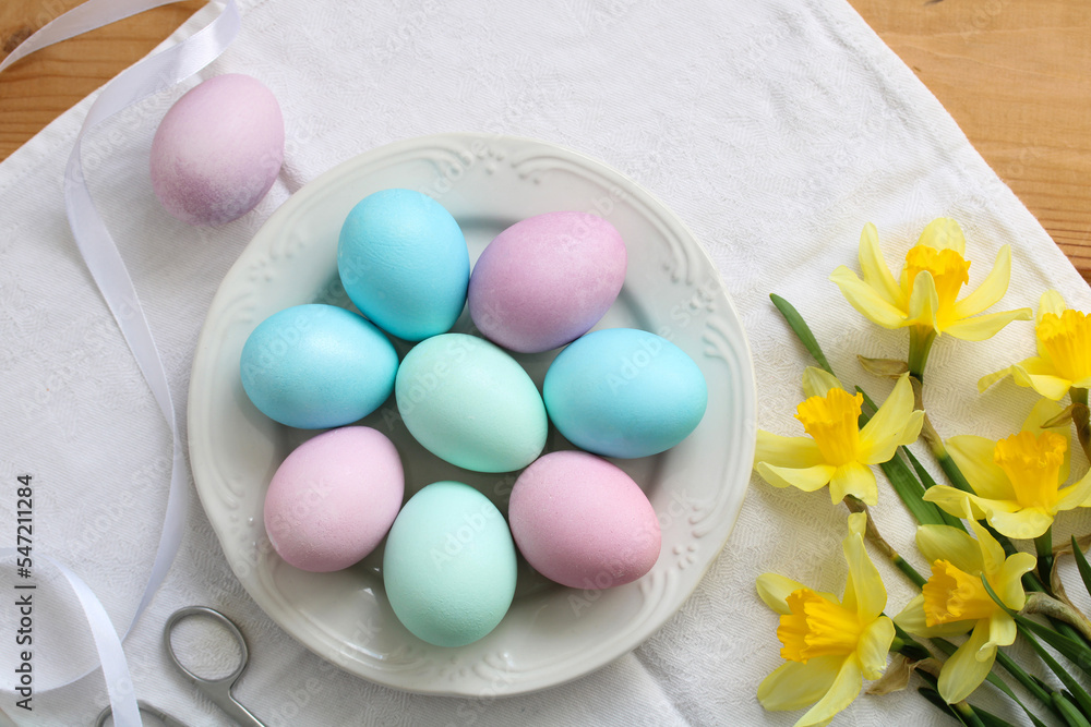 easter background with colorful eggs and daffodils on the table. easter background with colorful eggs and daffodils on the table.