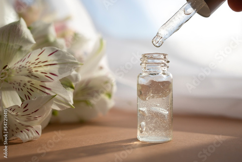 Glass dropper bottle with moisturizing lotion or facial serum. Side view.