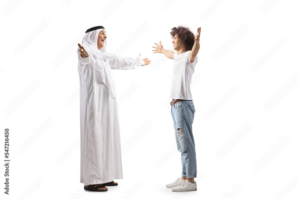 Full length profile shot of a mature arab man in a robe meeting a guy with curly hair