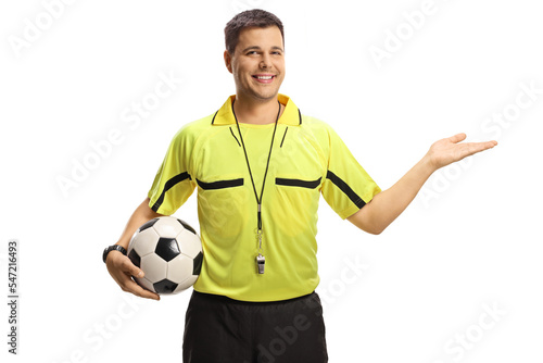Φωτογραφία Smiling football referee showing with hand and holding a ball