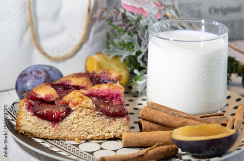 homemade plum pie, glass of milk and cinnamon sticks, home still-life 