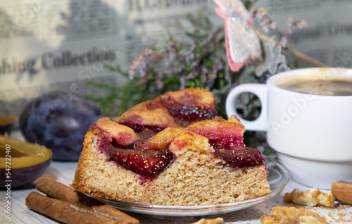 homemade rustic plum cake, cup of coffee and cinnamon sticks, food still-life 