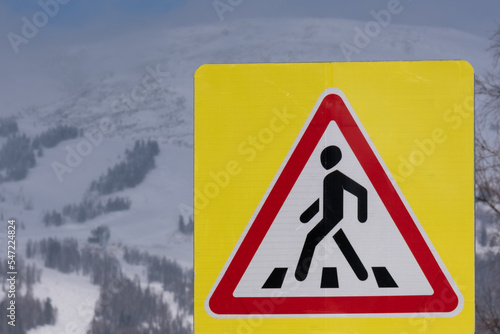 Pedestrian crossing and pedestrian sign. Mountains in the background