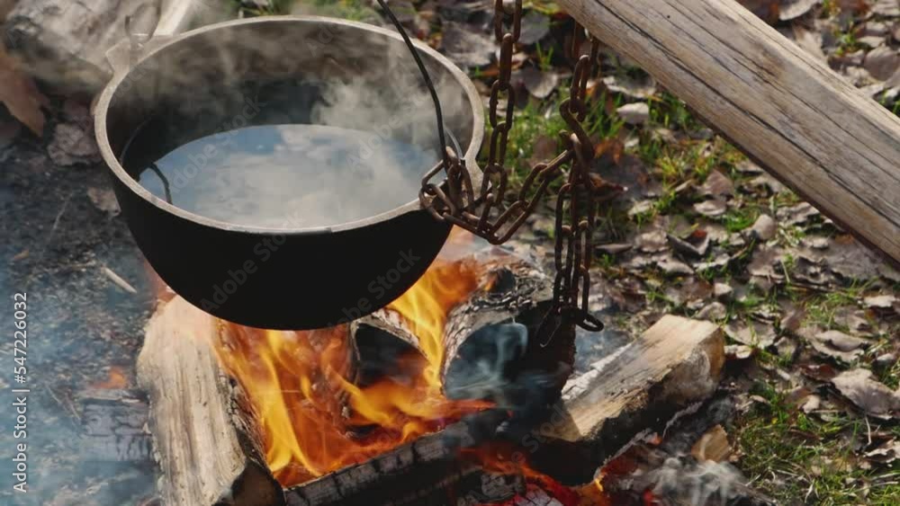 Preparing food on campfire in wild camping. Wild camping . Cooking food on a campfire in the woods. Selective focus. High quality FullHD footage Preparing food on campfire in wild camping. Wild camping . Cooking food on a campfire in the woods. Selective focus. High quality FullHD footage