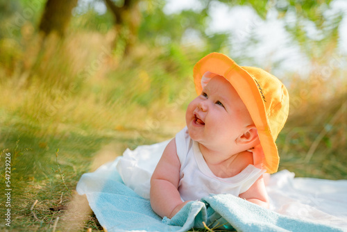 Funny baby toddler in a panama hat is relaxing on the beach outdoors in summer