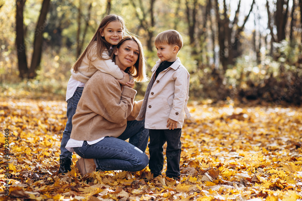 Mother with children having fun in autumn park