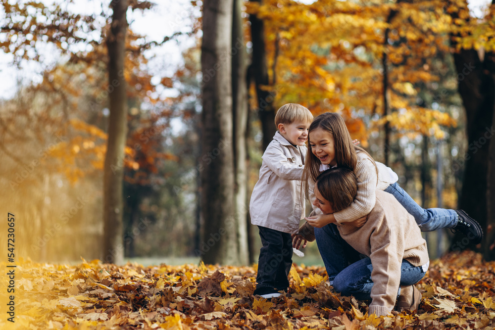 Mother with children having fun in autumn park Mother with children having fun in autumn park